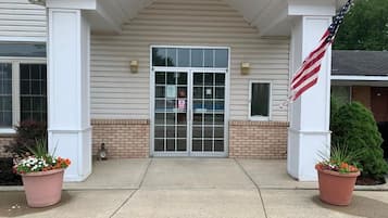 A building entrance with a double door, a small window, and an American flag.