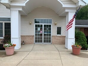 L'ingresso di un edificio con una doppia porta, una piccola finestra e la bandiera americana.