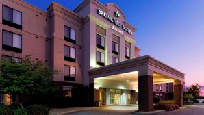 Un hotel Springhill Suites Marriott con una fachada moderna, un acceso cubierto y un camino de entrada arbolado.