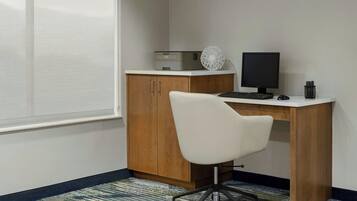 A small office space with a desk, chair, computer monitor, keyboard, and printer.