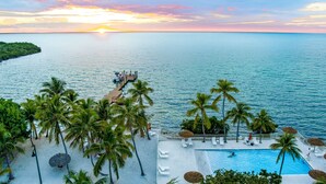 A resort with a swimming pool, lounge chairs, and palm trees. - Lime Tree Bay Resort (Long Key)
