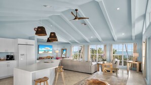 A spacious living area with a large island, wooden furniture, and a ceiling fan. - Lime Tree Bay Resort (Long Key)