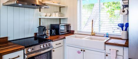 A kitchen with white cabinets, a stainless steel stove, a microwave, and a sink.