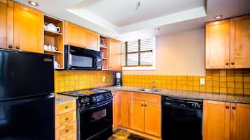 A kitchen with wooden cabinets, a black refrigerator, a microwave, a stove, and a dishwasher.