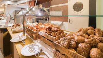 A buffet area with various baked goods displayed in wooden crates.