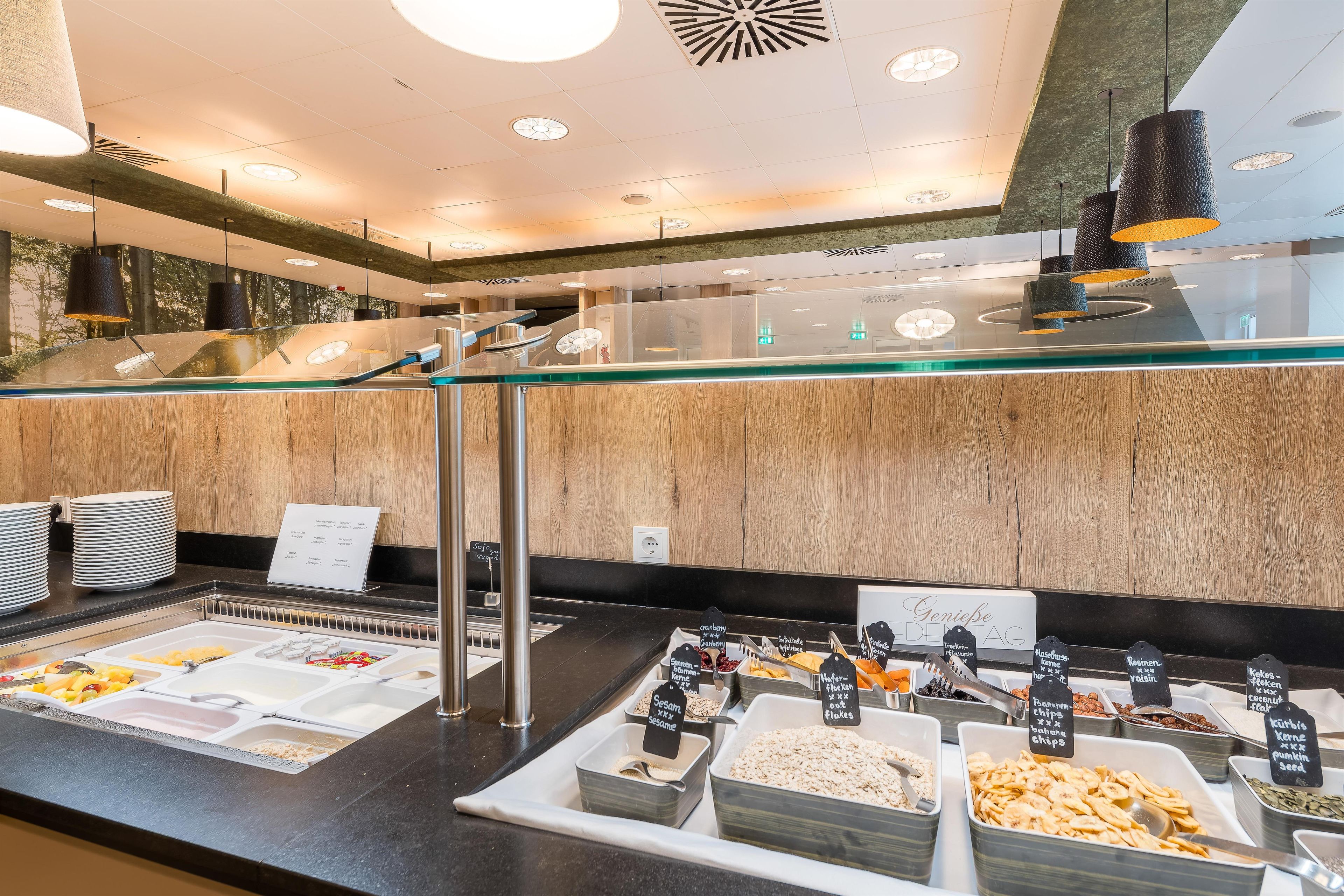 A buffet area with various food options and a glass partition.