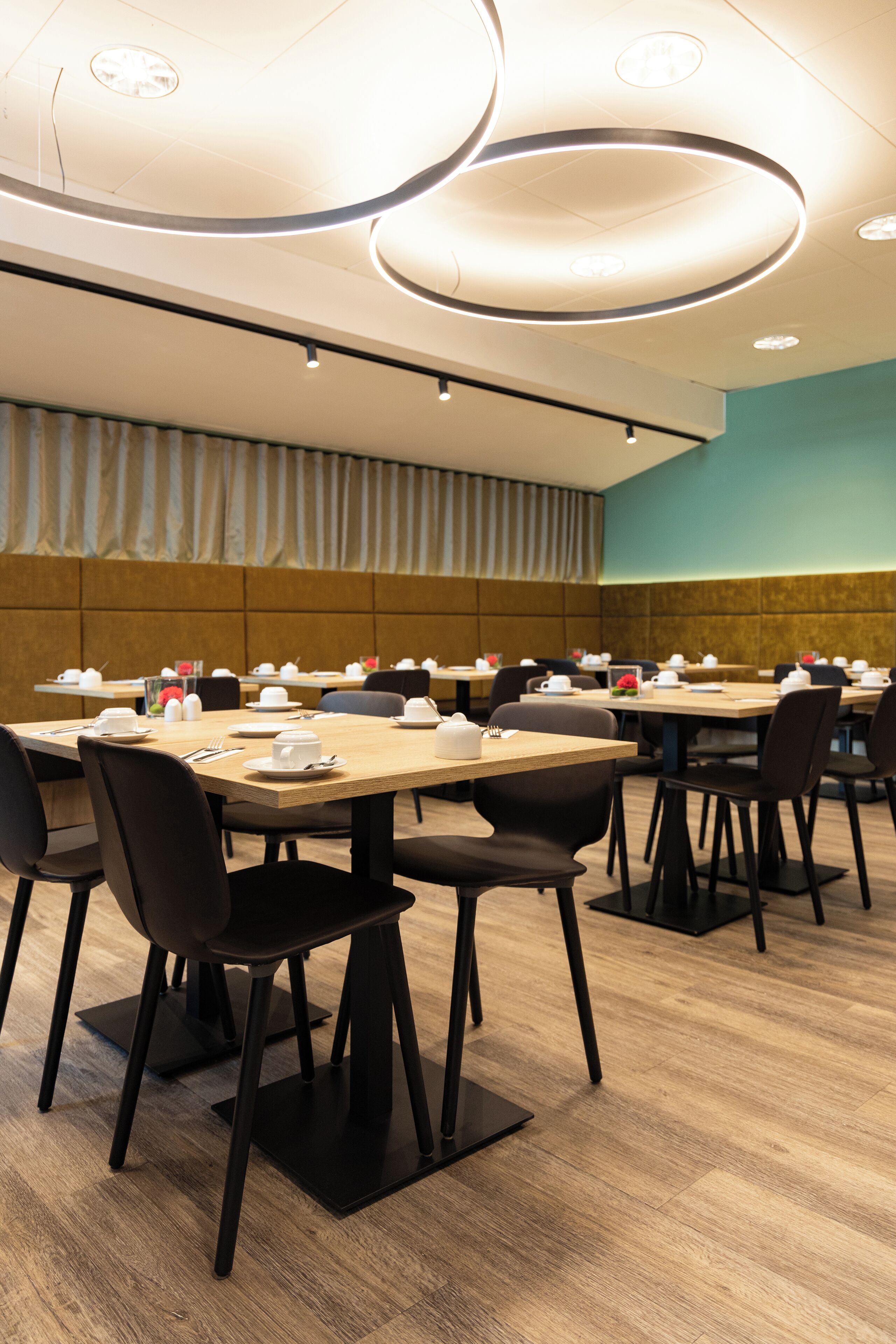 Un área de comedor moderna con varias mesas y sillas, dispuestas en un espacio amplio.