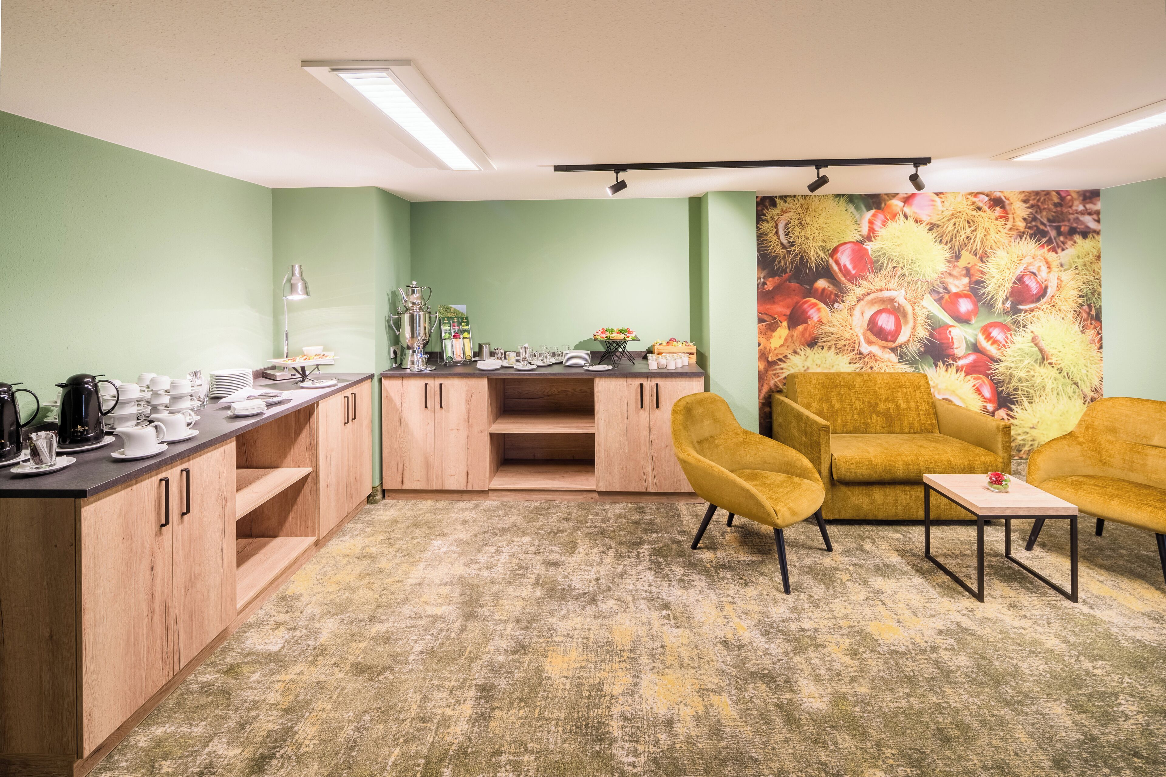 A cozy room with a kitchenette, a sofa, and a coffee table.