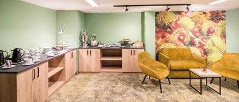 A cozy room with a kitchenette, a sofa, and a coffee table.