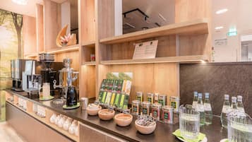 A coffee bar with espresso machines, a variety of coffee beans, and a selection of teas.
