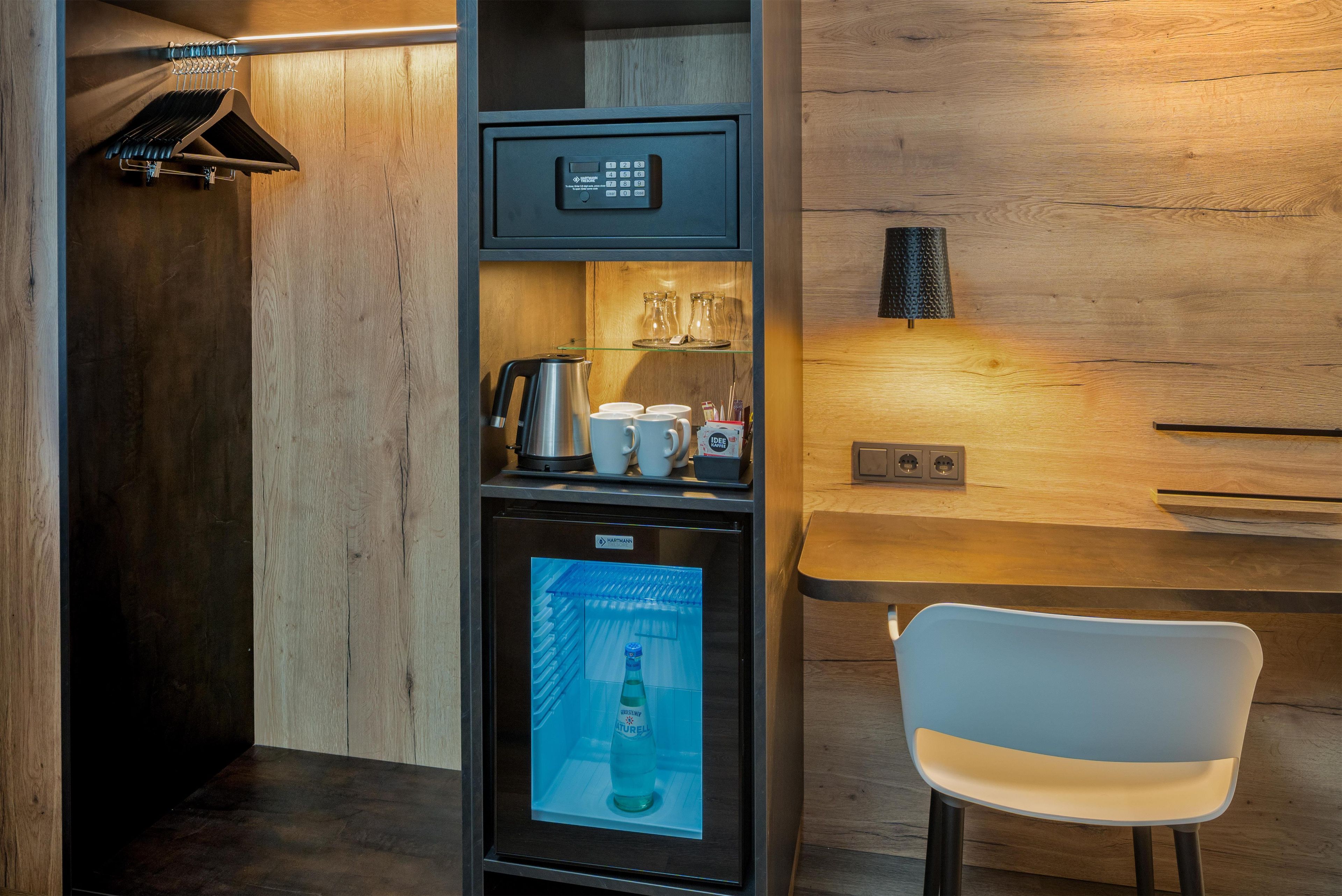 A compact kitchenette with a coffee machine, a small refrigerator, and a microwave.