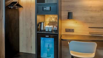Eine kompakte Küchenzeile mit Kaffeemaschine, kleinem Kühlschrank und Mikrowelle.