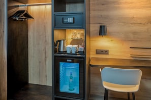 A compact kitchenette with a coffee machine, a small refrigerator, and a microwave.