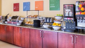 Een ontbijtbuffet met diverse etenswaren en een koffieapparaat.