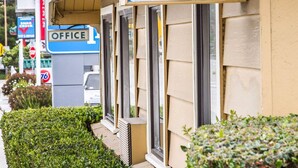 Une enseigne Rodeway Inn sur un bâtiment, avec une pancarte indiquant la présence de bureaux et un panneau de signalisation « stop » en arrière-plan.