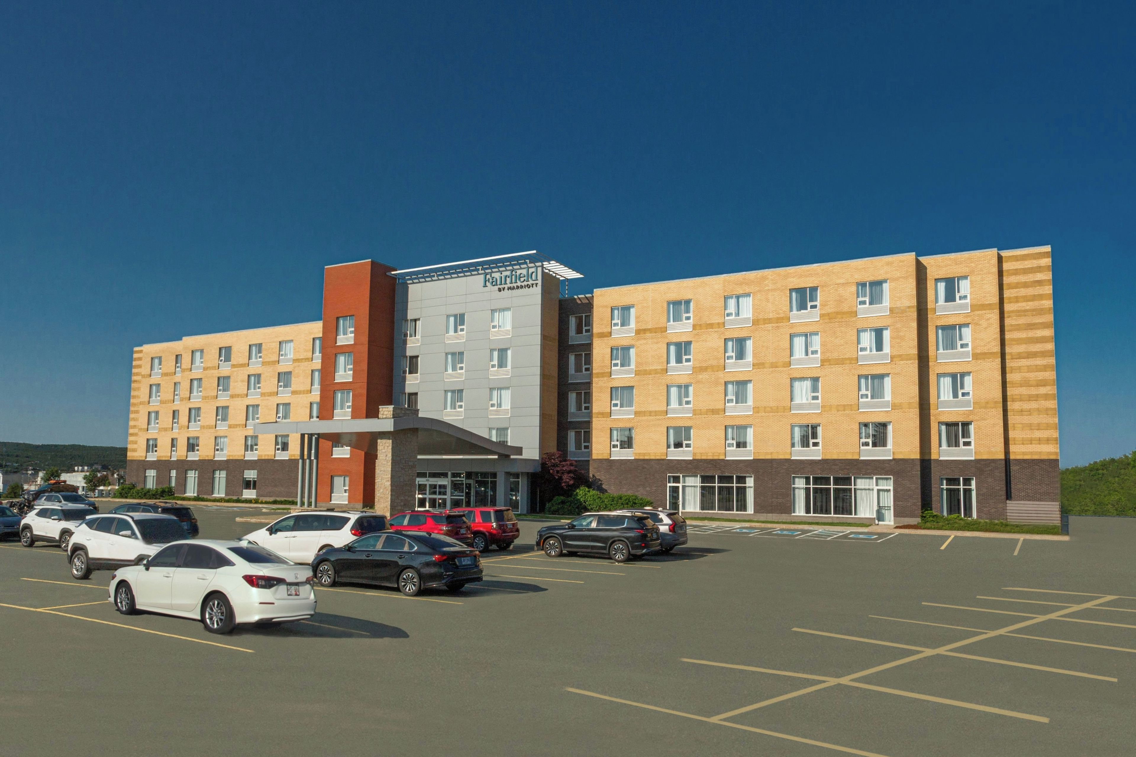 A multi-story hotel with a parking lot in front.