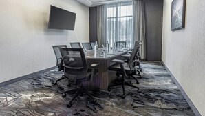 A conference room with a long table, chairs, a flat-screen TV, and a large window with curtains. - Fairfield Inn & Suites by Marriott St. John's Newfoundland (St. John's)