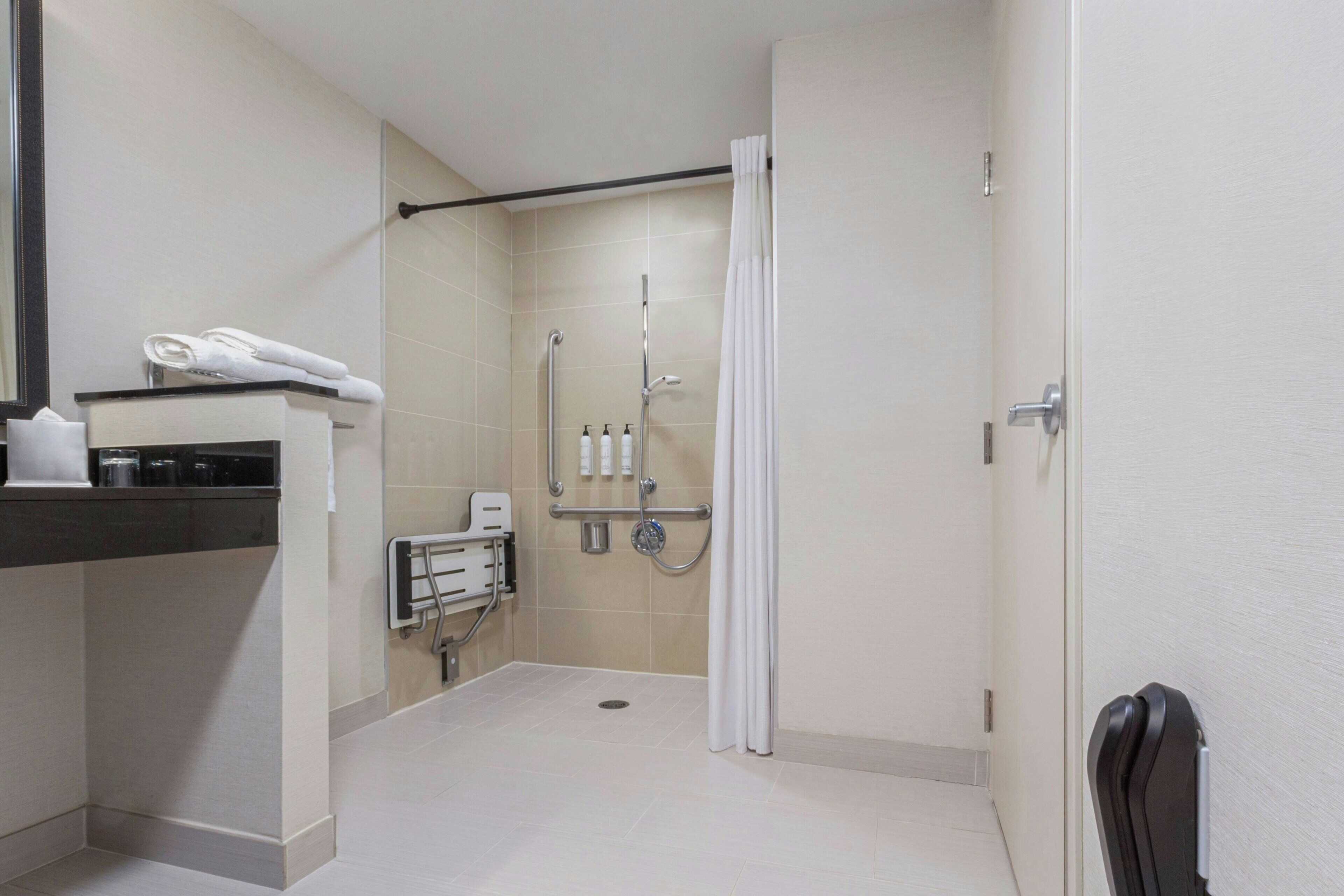 A modern bathroom with a shower, toilet, and sink.