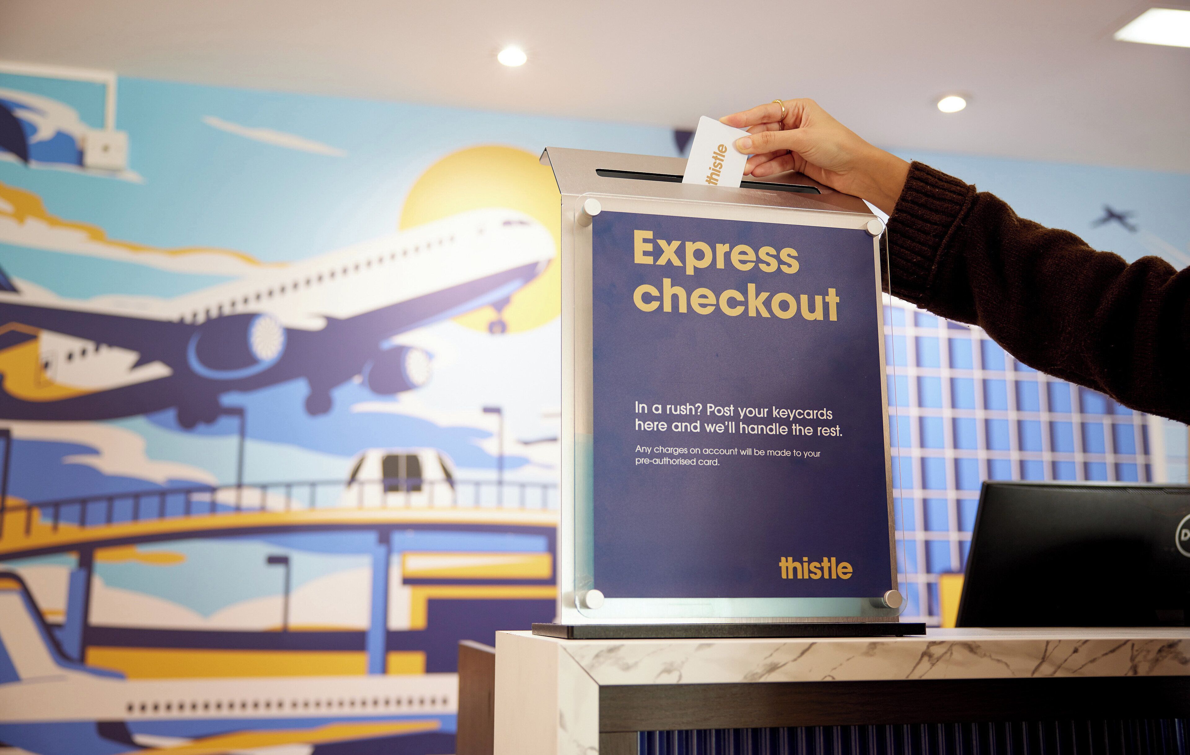 A person inserting a card into an express checkout machine at an airport.