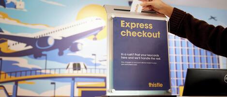 A person inserting a card into an express checkout machine at an airport.