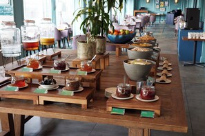 A buffet setup with various food items and condiments. - Thistle London Heathrow Terminal 5 (West Drayton)