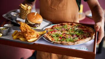 A tray with a burger, fries, and a pizza.