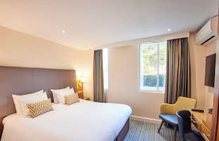 Ropa de cama hipoalergénica y caja de seguridad en la habitación