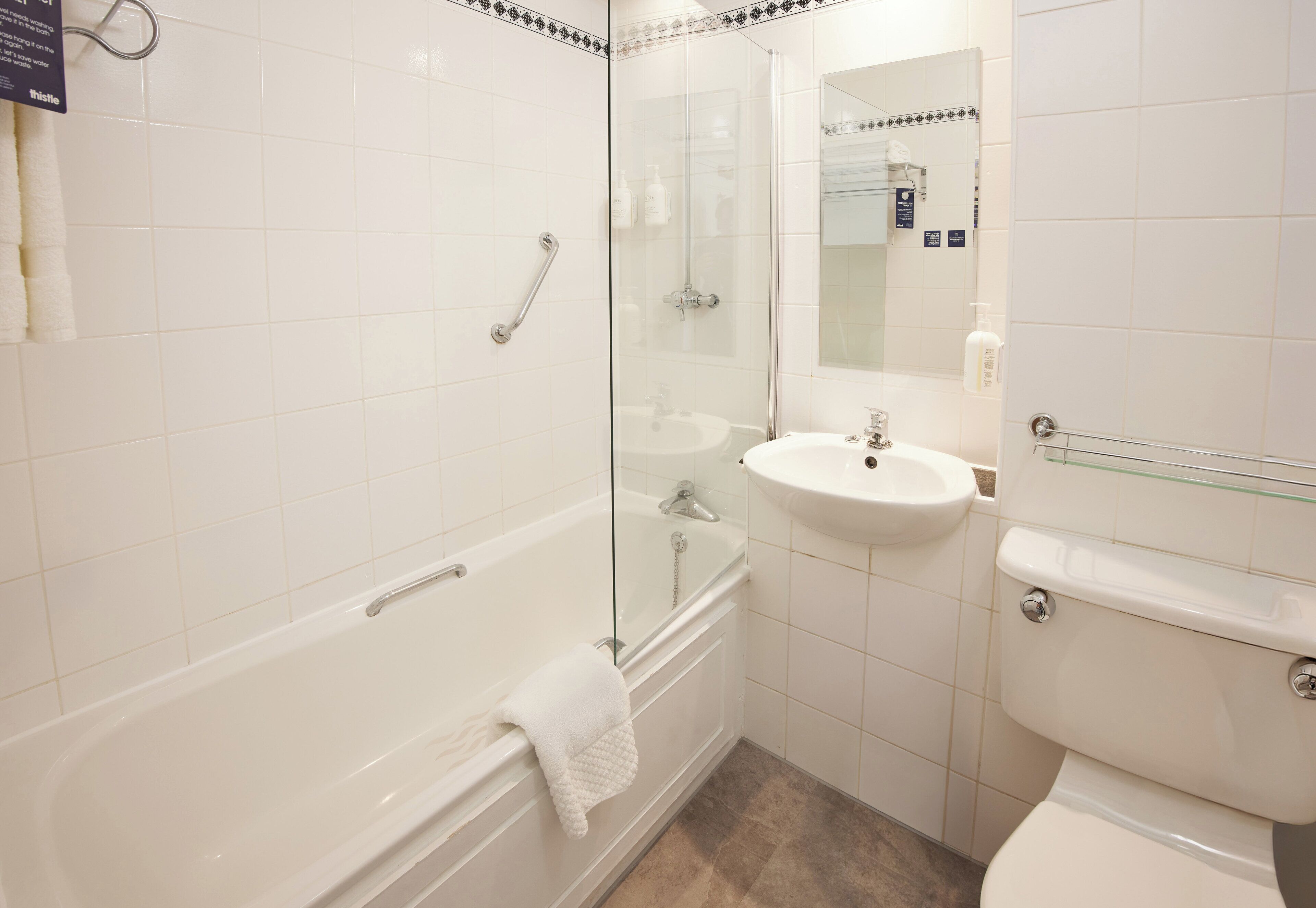 Een badkamer met een douchecabine, een witte badkuip en een wastafel met spiegel.