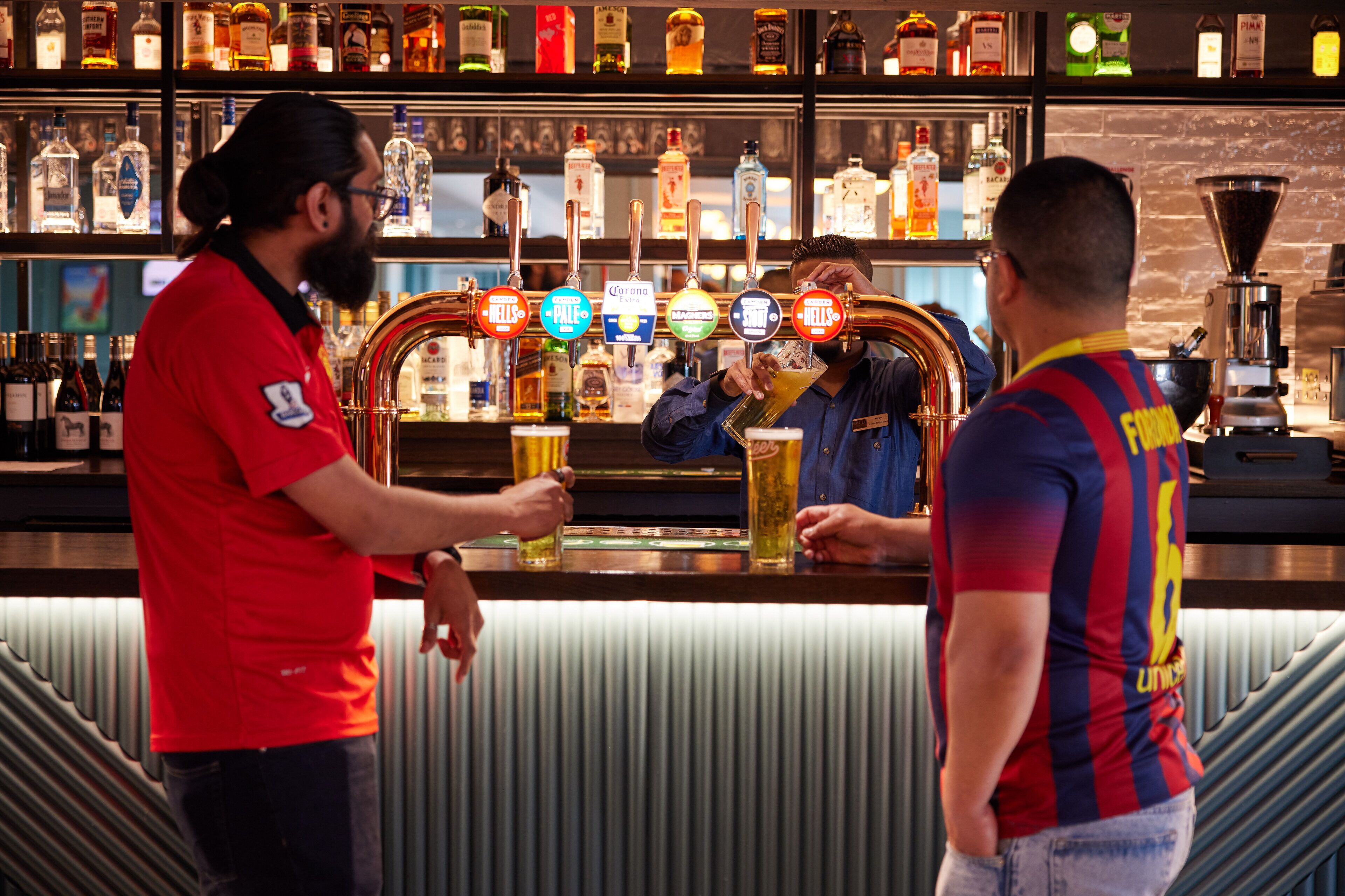 A bar with multiple liquor bottles and a beer tap.