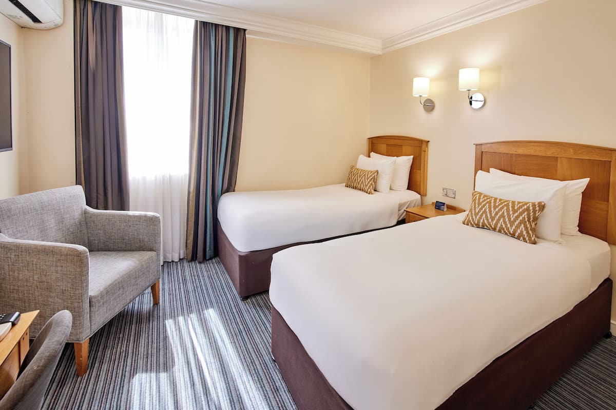 Ropa de cama hipoalergénica y caja de seguridad en la habitación