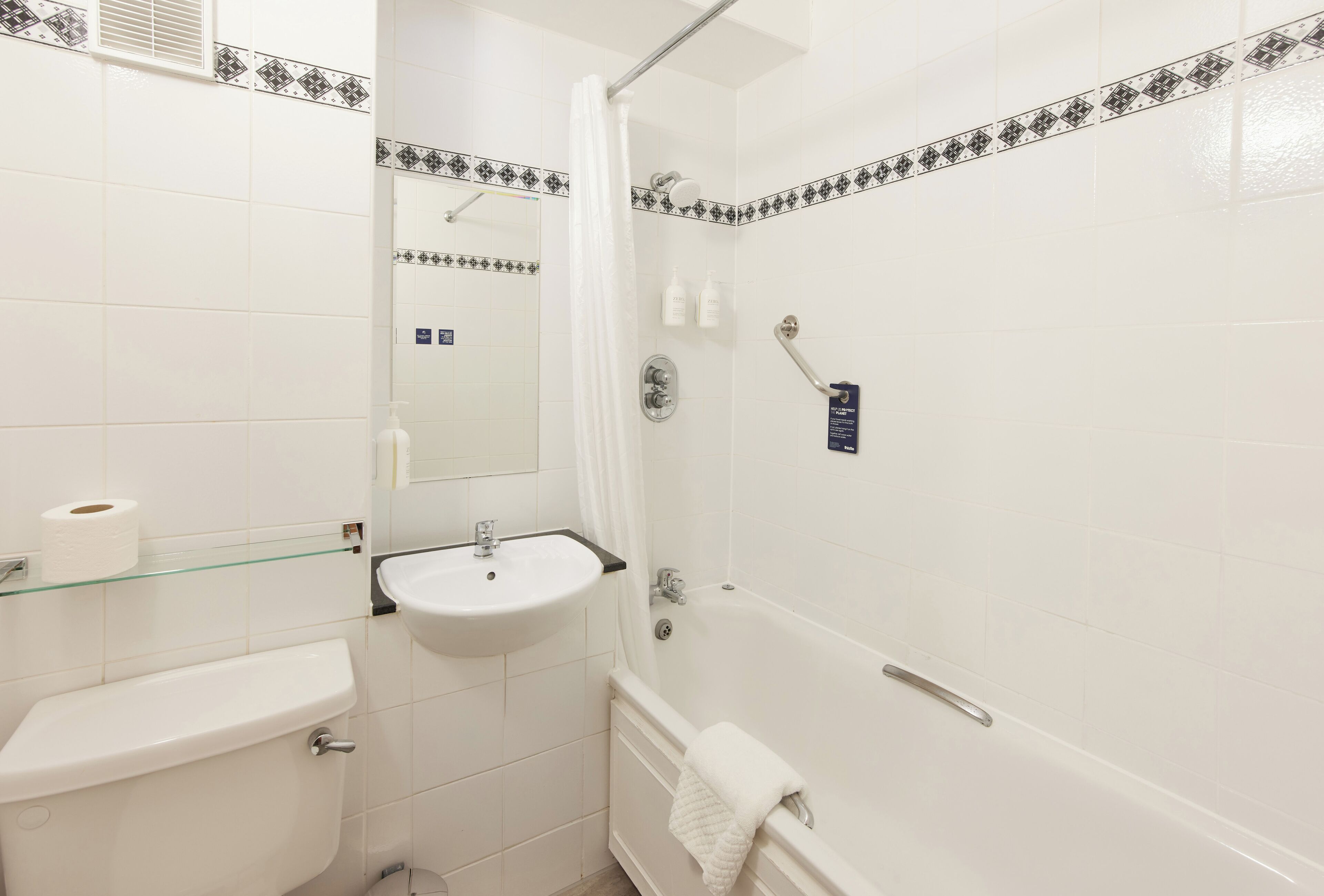 A bathroom with a toilet, sink, and bathtub.