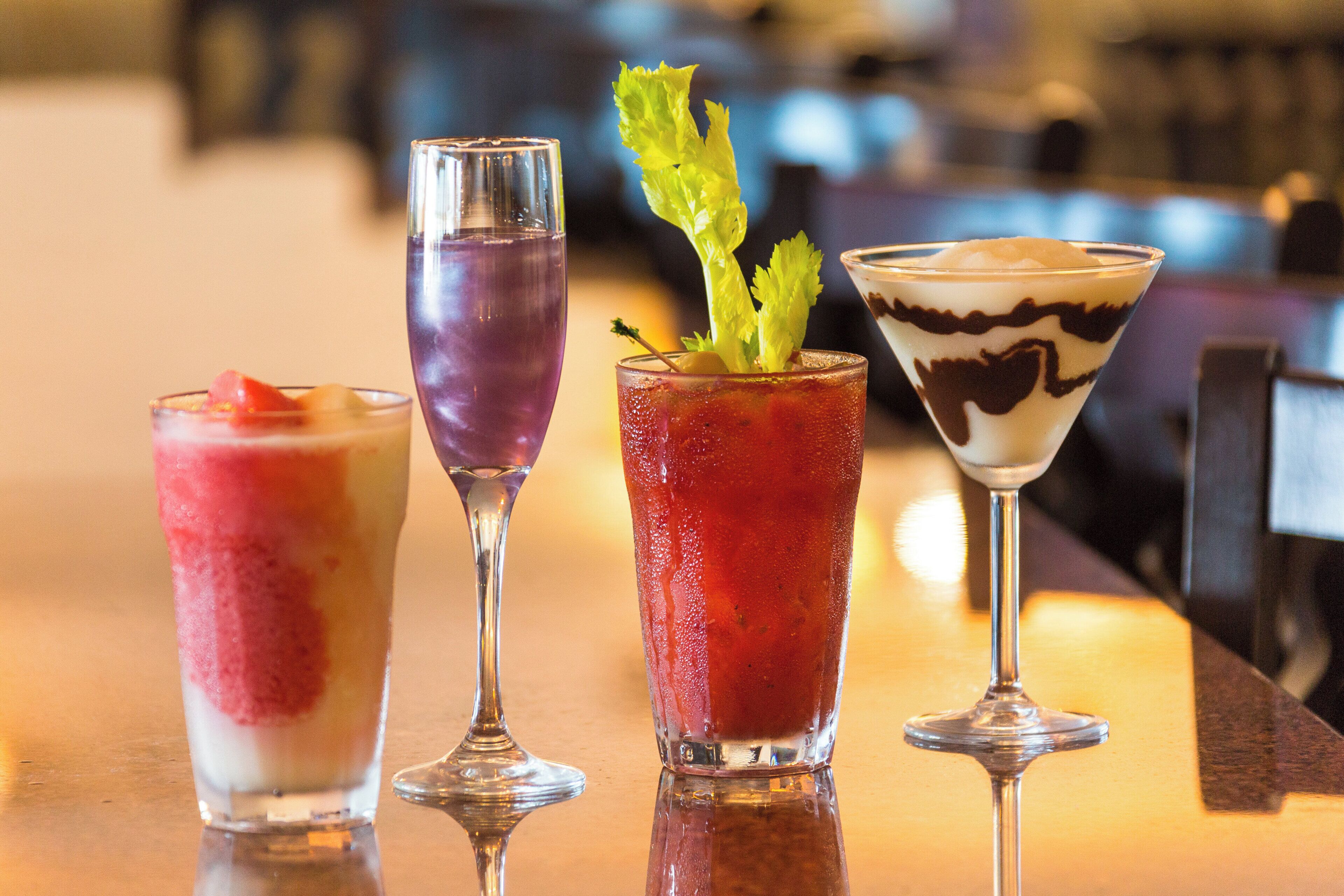 Three different cocktails on a bar counter.