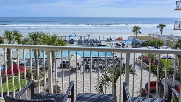 A beachside resort with a pool, lounge chairs, and umbrellas. - Holiday Inn Resort Daytona Beach Oceanfront by IHG (Daytona Beach)