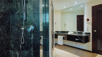 Een moderne badkamer met douche, wastafel en grote spiegel.