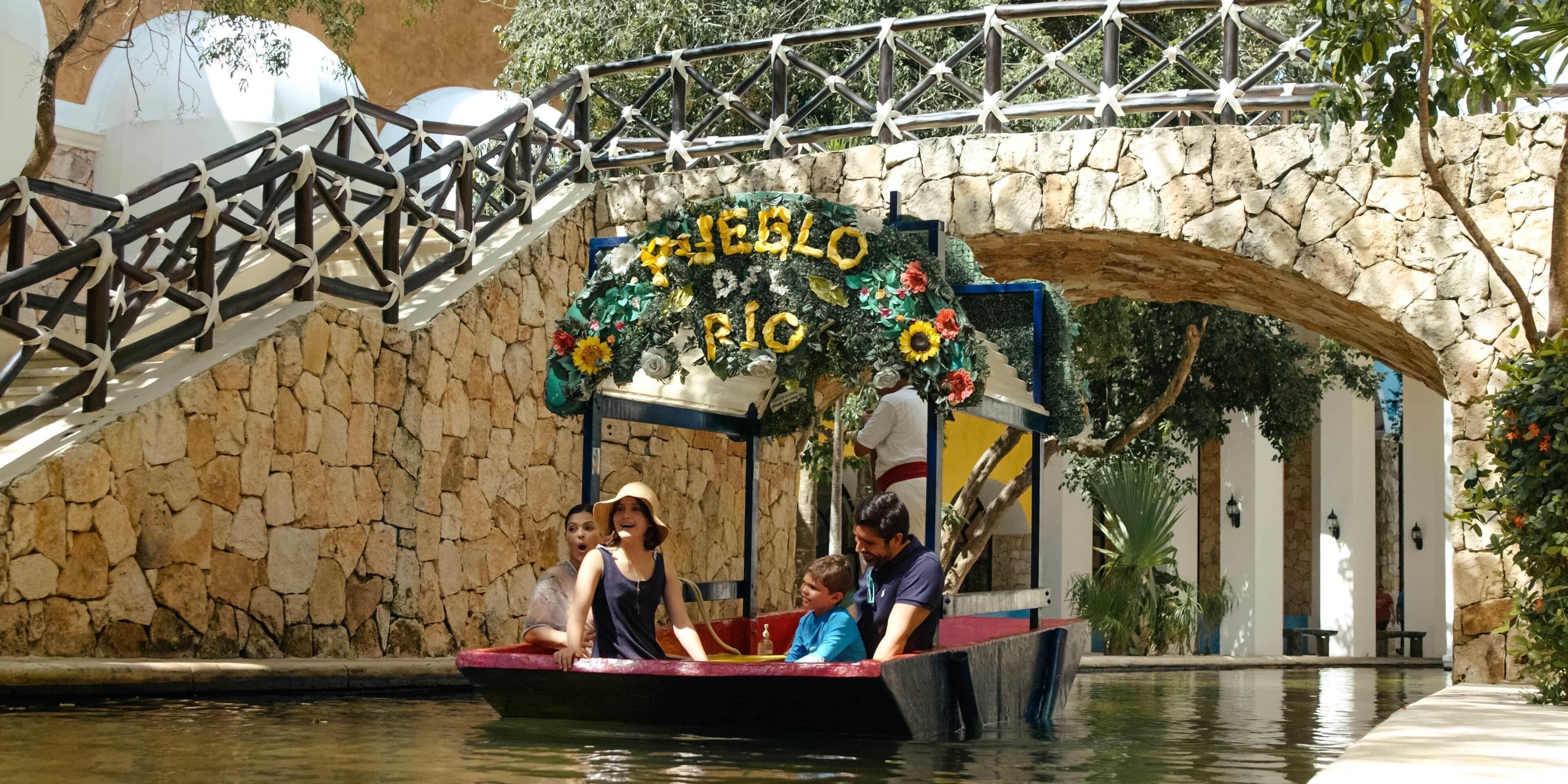Un paseo en bote con un puente de piedra y un letrero que dice "JEBEL RIO".