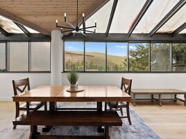 A dining area with a wooden table, chairs, and a potted plant.