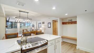 A modern kitchen with a large island, built-in oven, and stainless steel appliances.