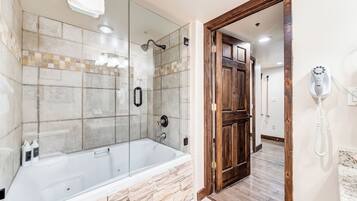 Un baño con ducha de vidrio, bañera y puerta de madera.