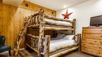 Cozy bedroom with a rustic bunk bed, wooden dresser, and star-shaped decoration.