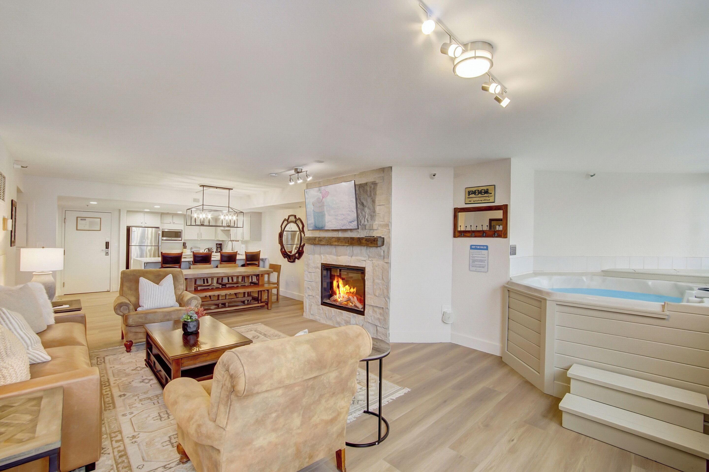 Una sala de estar moderna con chimenea, bañera de hidromasaje y comedor.