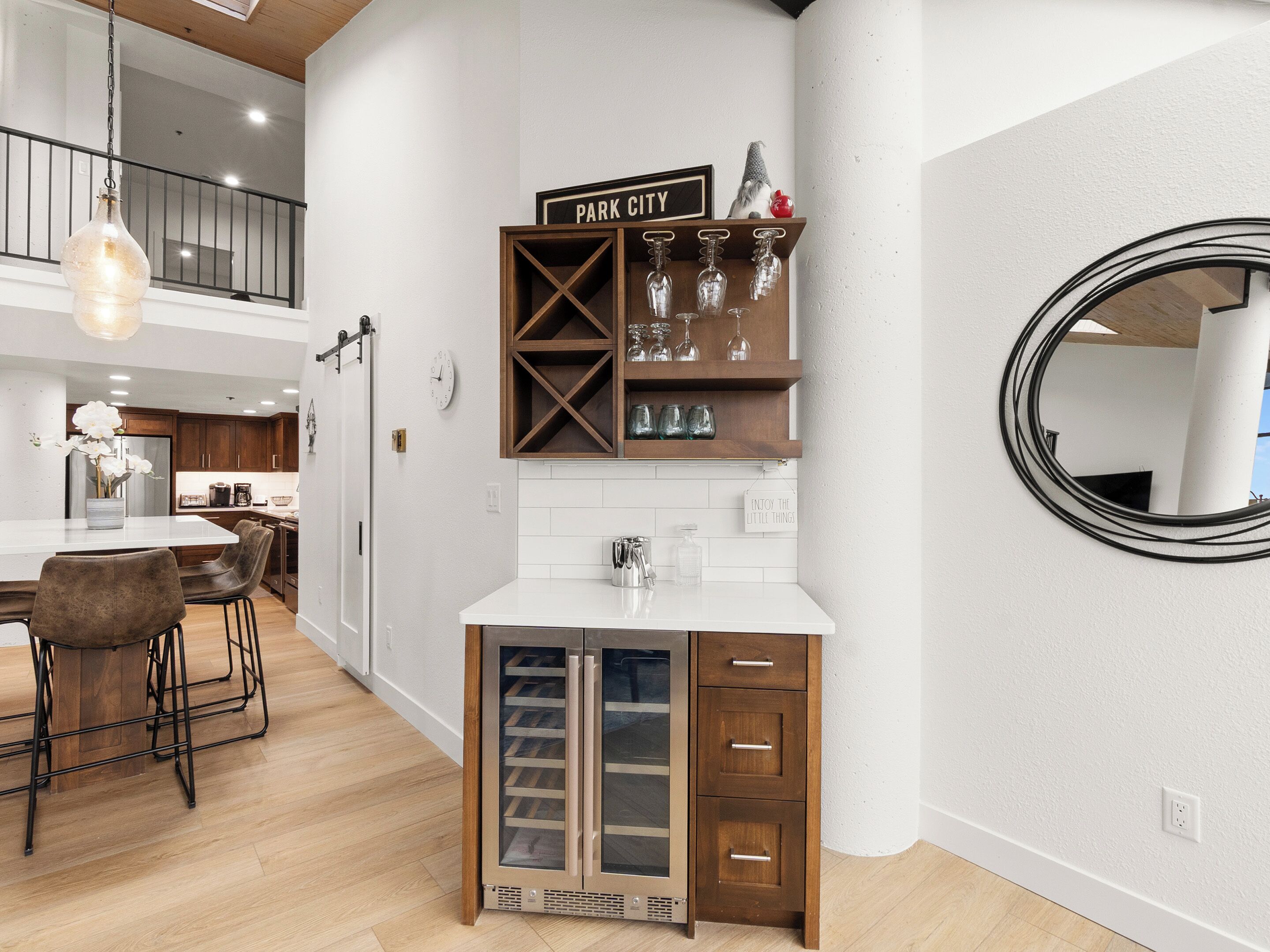 Eine moderne Küche mit weißer Arbeitsplatte, Holzschränken und einem Weinkühlschrank.