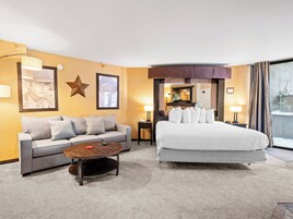 Une chambre d’hôtel avec un canapé, un lit, une table basse et un téléviseur.