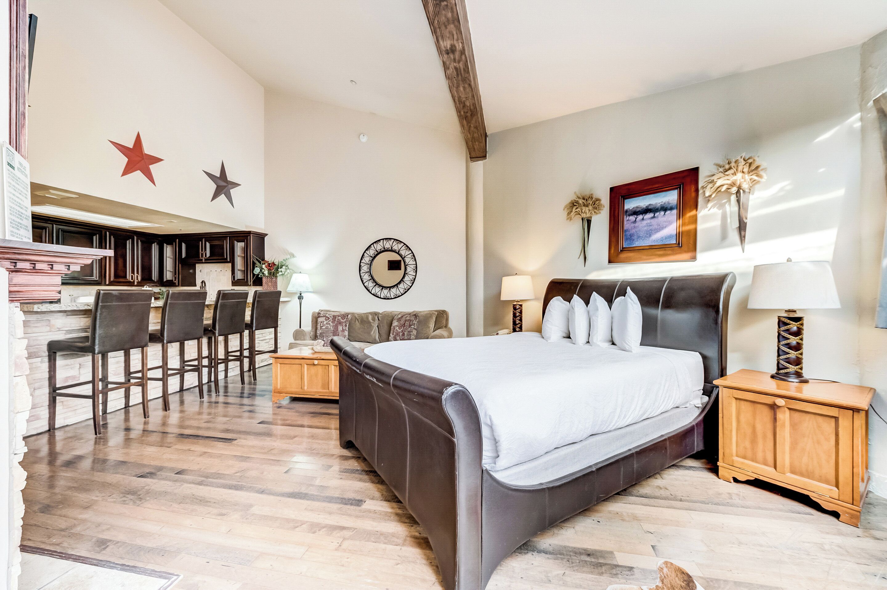 Un dormitorio con una cama grande, una mesita de noche de madera, un reloj de pared y una decoración con estrellas.