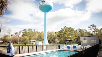Una piscina al aire libre, sillones reclinables de piscina