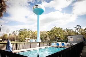 Una piscina al aire libre, sillones reclinables de piscina