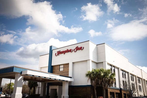 A Hampton Inn hotel with a clear sky and clouds.