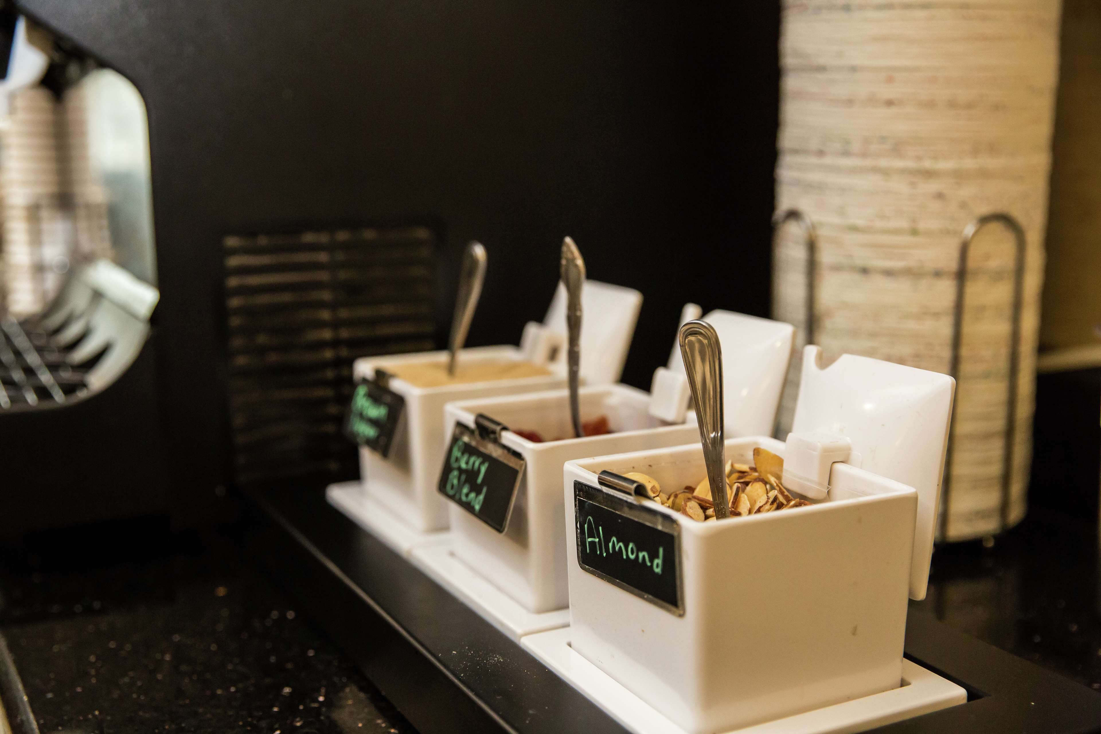 Una estación de café con dispensadores etiquetados para distintos tipos de café.