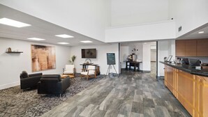 A spacious lobby with a reception desk, seating area, and a chalkboard for announcements. - Sonesta Essential Vacaville - Napa Valley (Vacaville)
