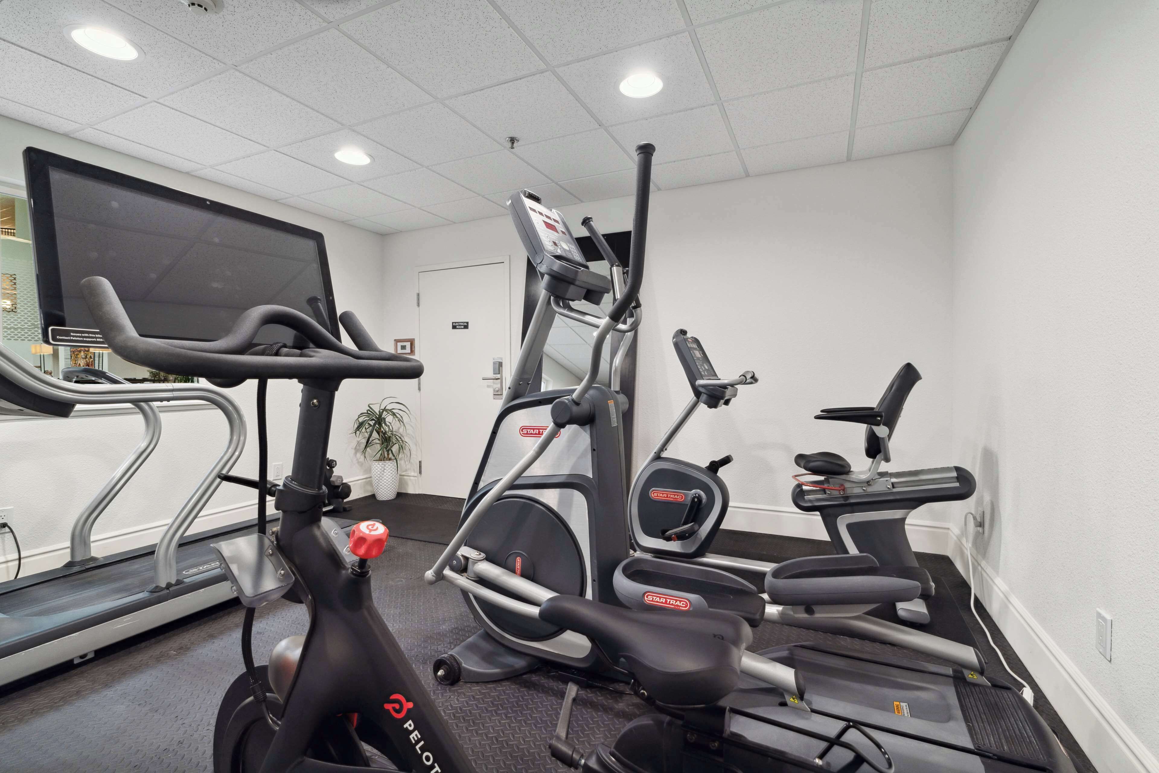 A gym with treadmills, an elliptical, and a stationary bike.