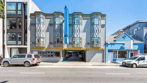 Een gebouw met een moderne gevel, grote ramen en een blauw zonnescherm.